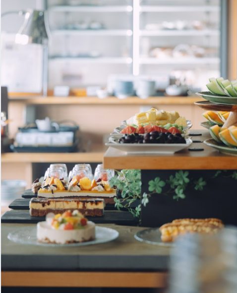 ビュッフェ台に並ぶケーキやフルーツ